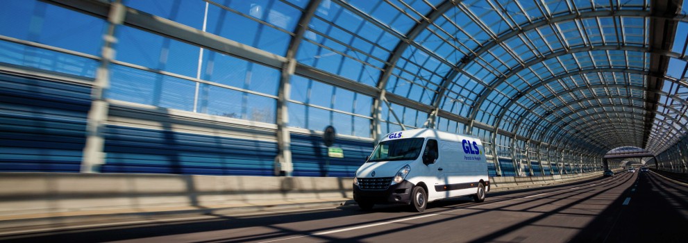 Een camionnette rijdt binnen een glazen tunnel