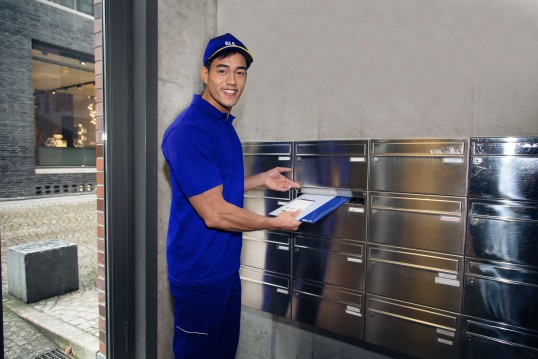 Mensajero dejando carta en un buzón