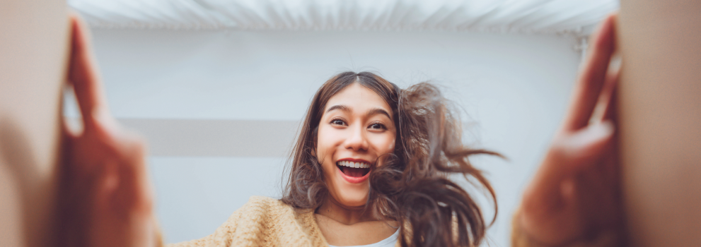 Dziewczyna otwiera paczkę od kuriera