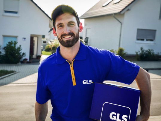 Distribuidor GLS com uniforme a segurar uma encomenda